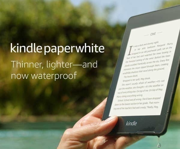 A person holding the Kindle with the page very clear to see while outside by the pool
