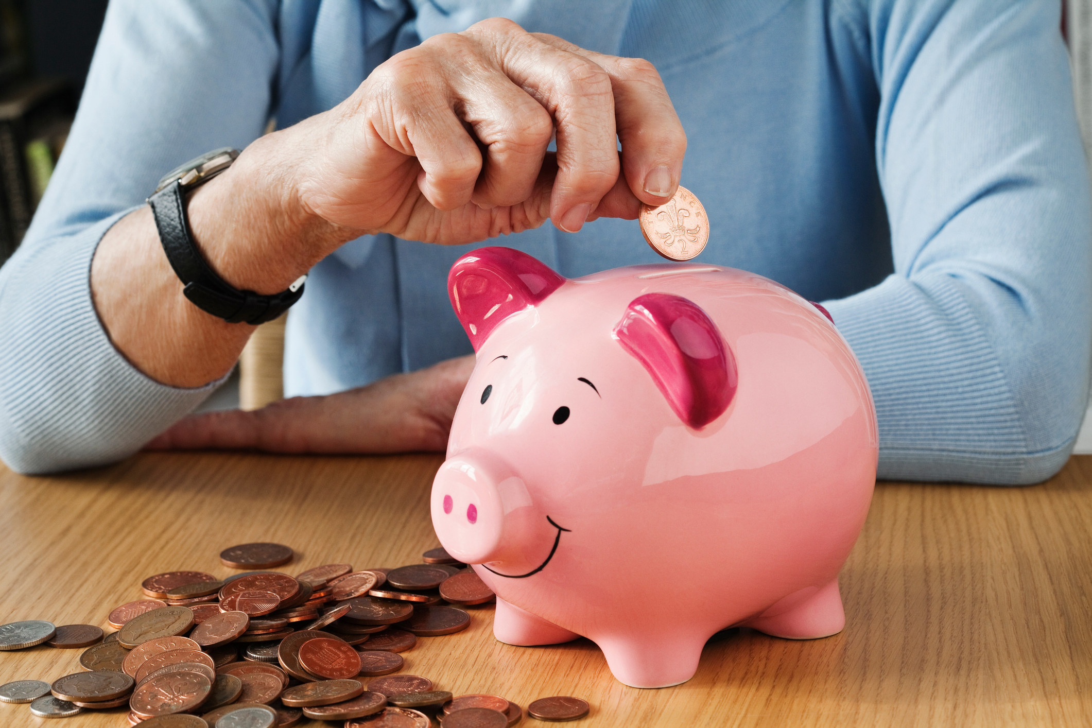 Person putting money into a piggy bank