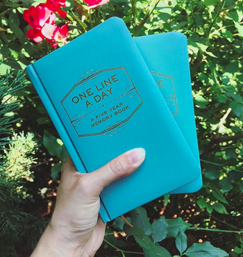 A reviewer holding the turquoise-colored book