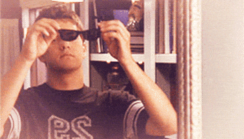 Pacey putting on sunglasses and smiling.