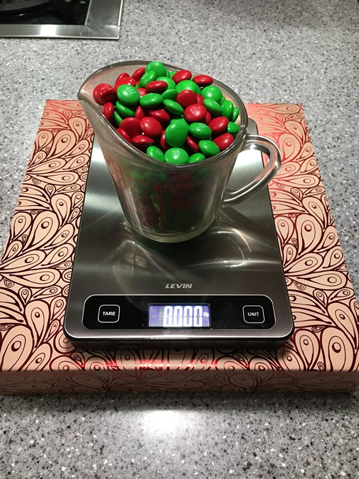 reviewer image of a measuring cup full of m&amp;amp;m&#x27;s on the levin digital scale