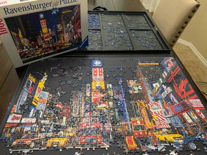 The puzzle board with portions of a completed puzzle on it and puzzle pieces in the sorting trays