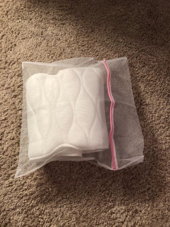A reviewer's photo of the pillow folded up and stored in the included mesh bag