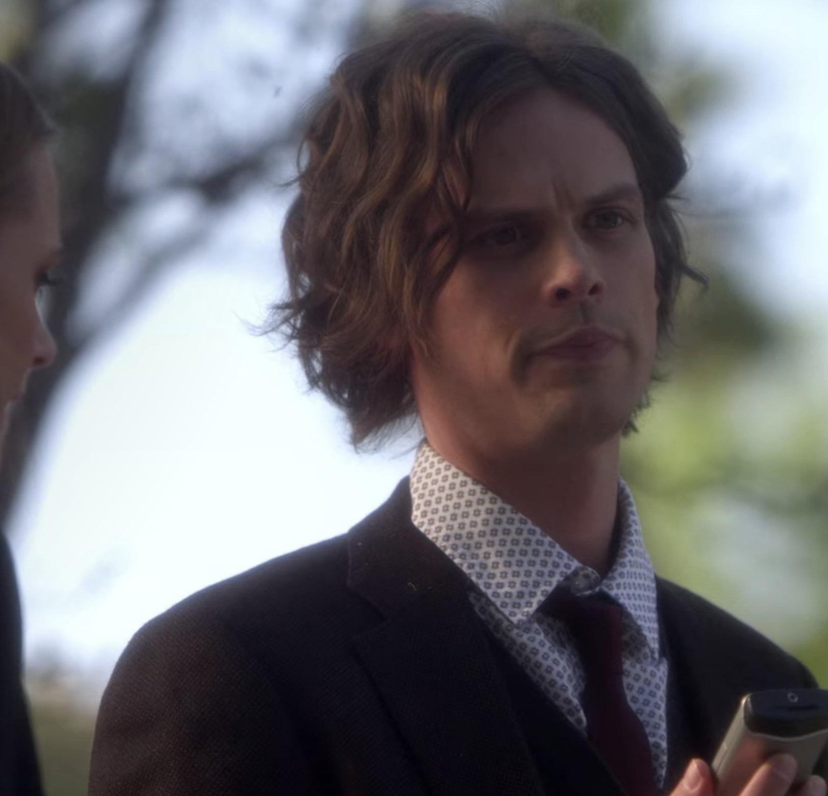 Spencer Reid from Criminal Minds talking and holding a phone