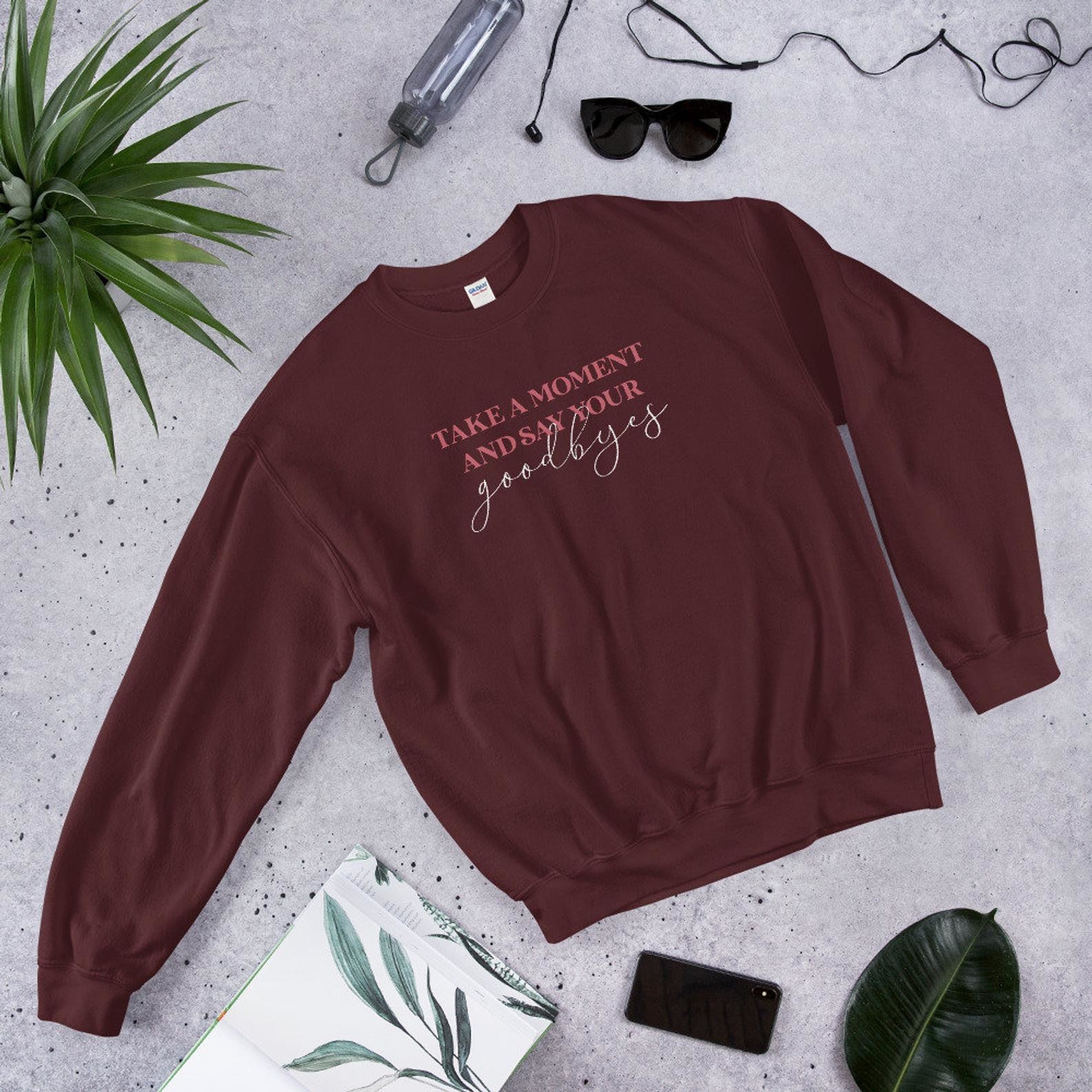 a maroon sweatshirt with the quote &quot;take a moment and say your goodbyes&quot; on it