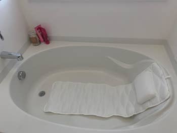A reviewer's photo of the pillow in their tub
