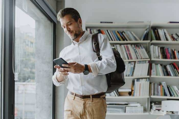 Photo of a man using his cellphone in his office