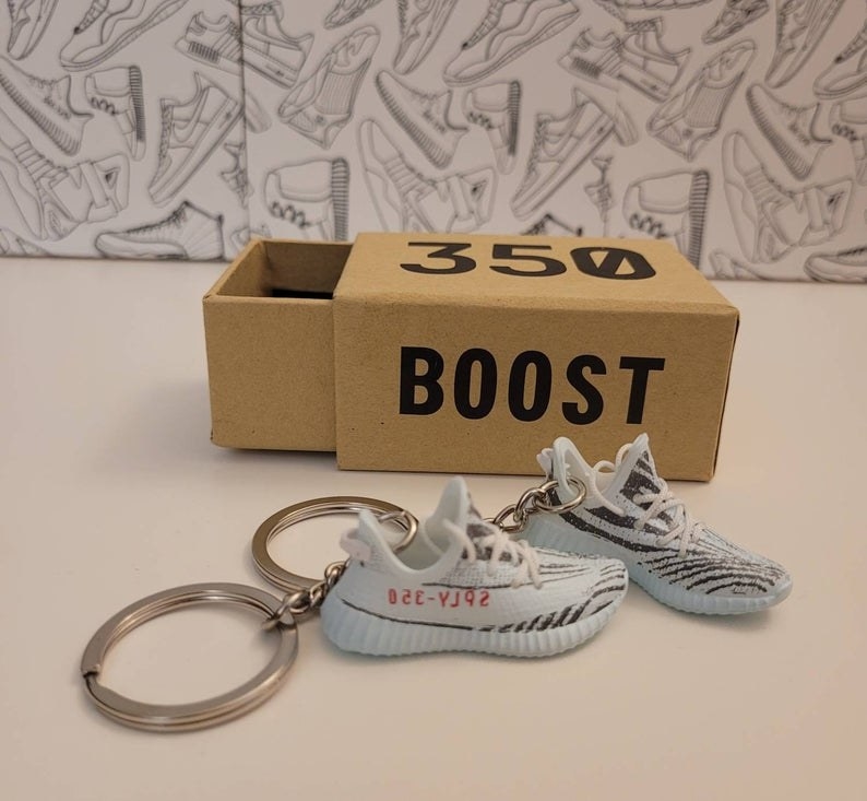 two Yeezy sneaker keychains and a mini shoe box 