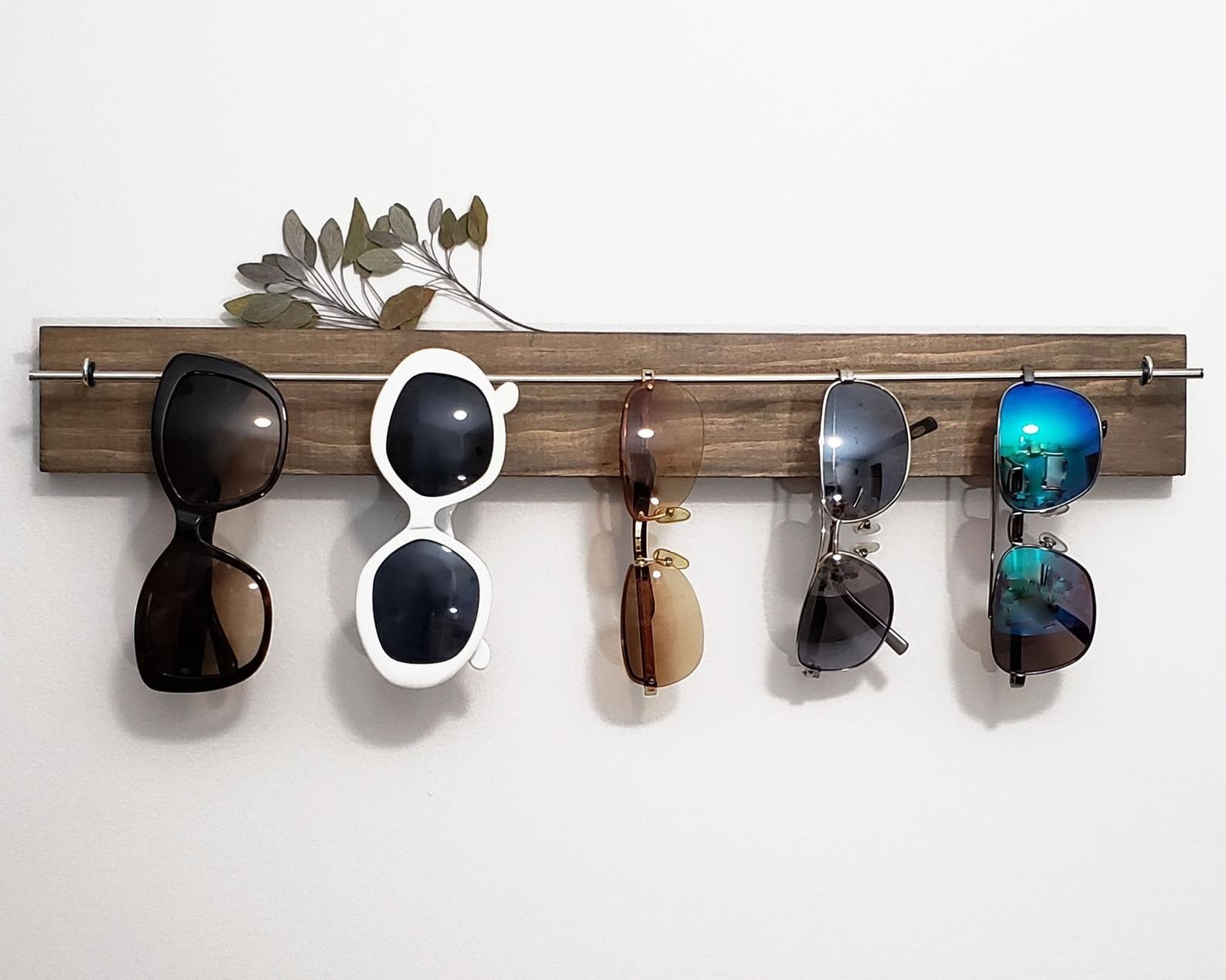 five pairs of sunglasses hanging on the sunglasses holder