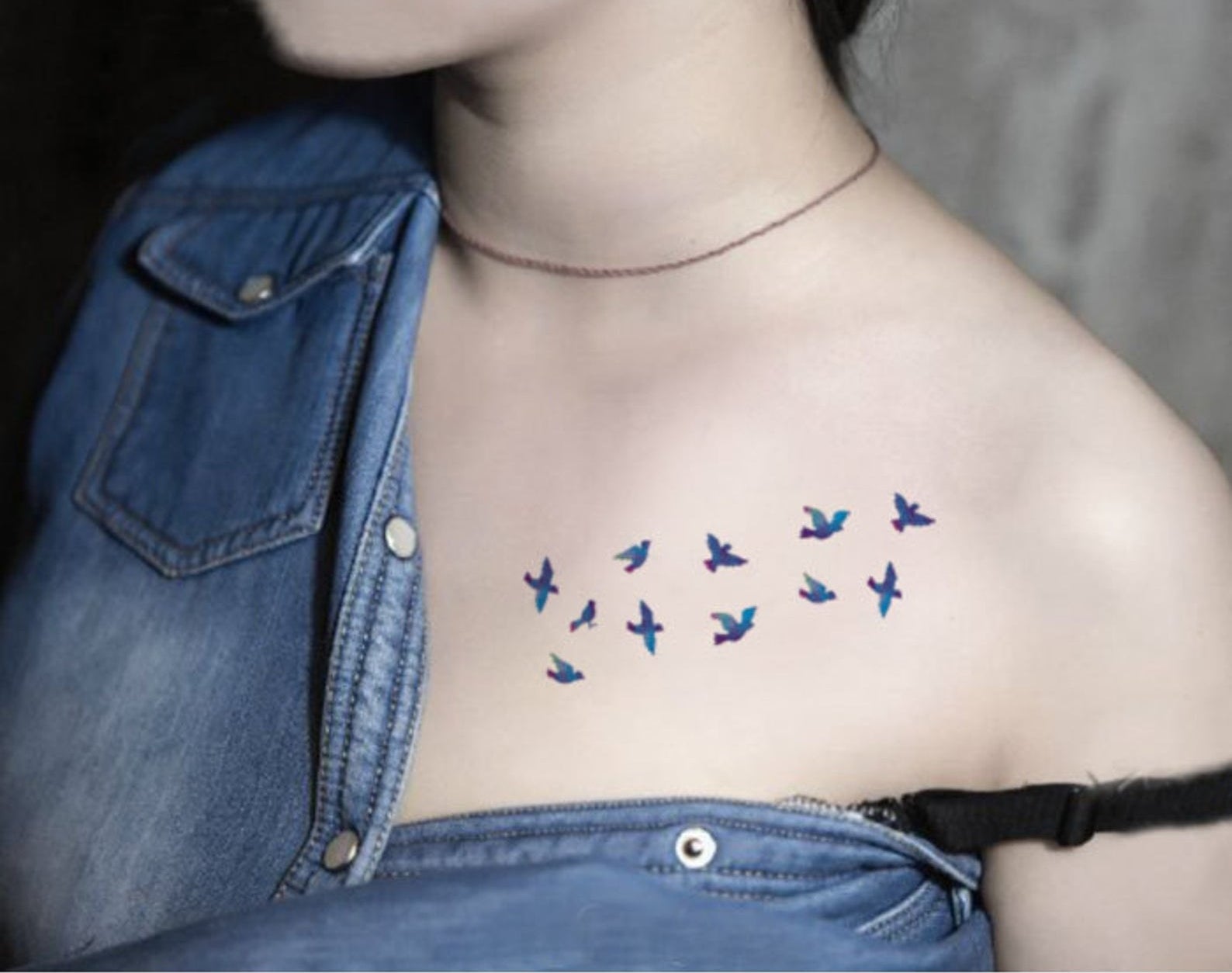  model with a string of bluebird tattoos on their shoulder 
