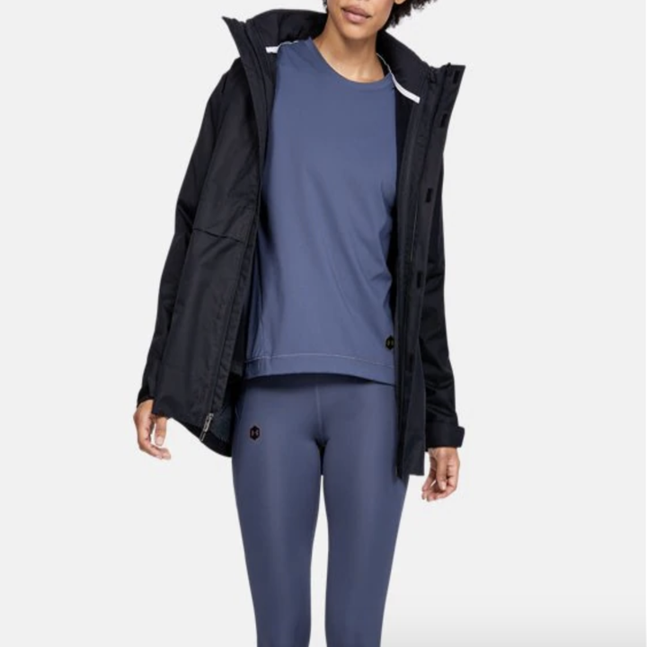 Model in a black  running coat with hood 