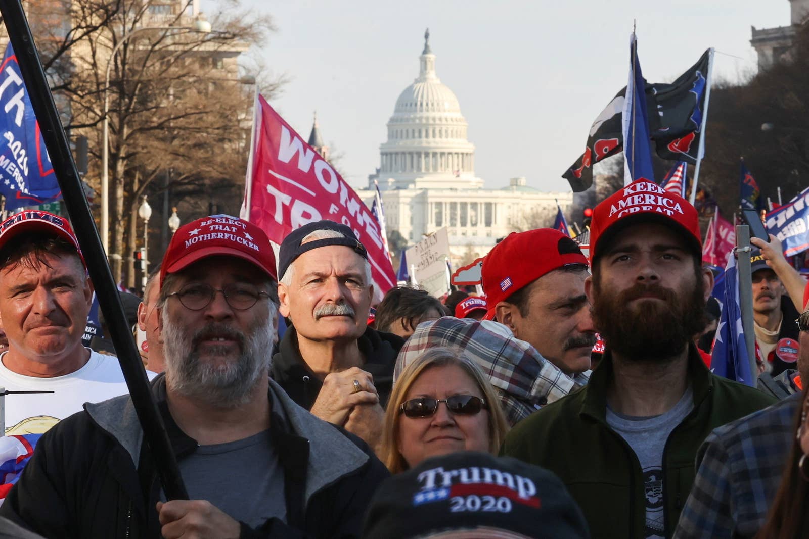 A large group of people wearing Trump paraphernalia with the US Capitol seen in the background