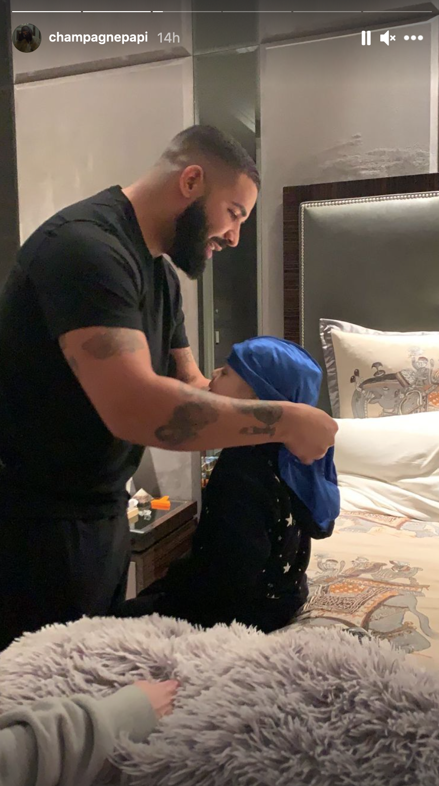 Drake ties a silk durag on Adonis&#x27;s head while Adonis sits on a bed