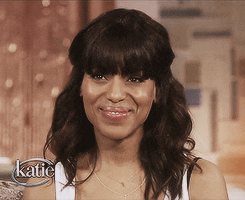 Kerry Washington in an interview covers her face as if reacting to something adorable