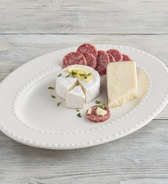 White small oval shaped platter with cheese on it 