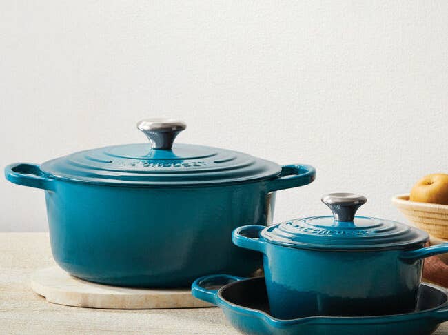 Two Dutch ovens in deep teal
