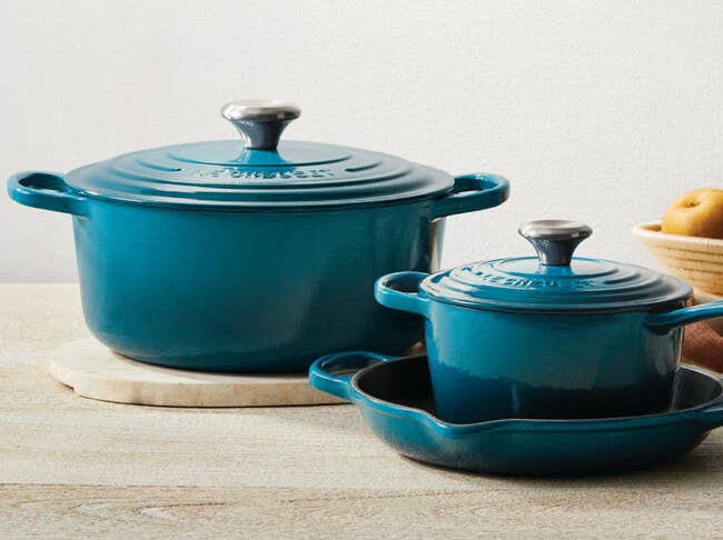 Two Dutch ovens in deep teal