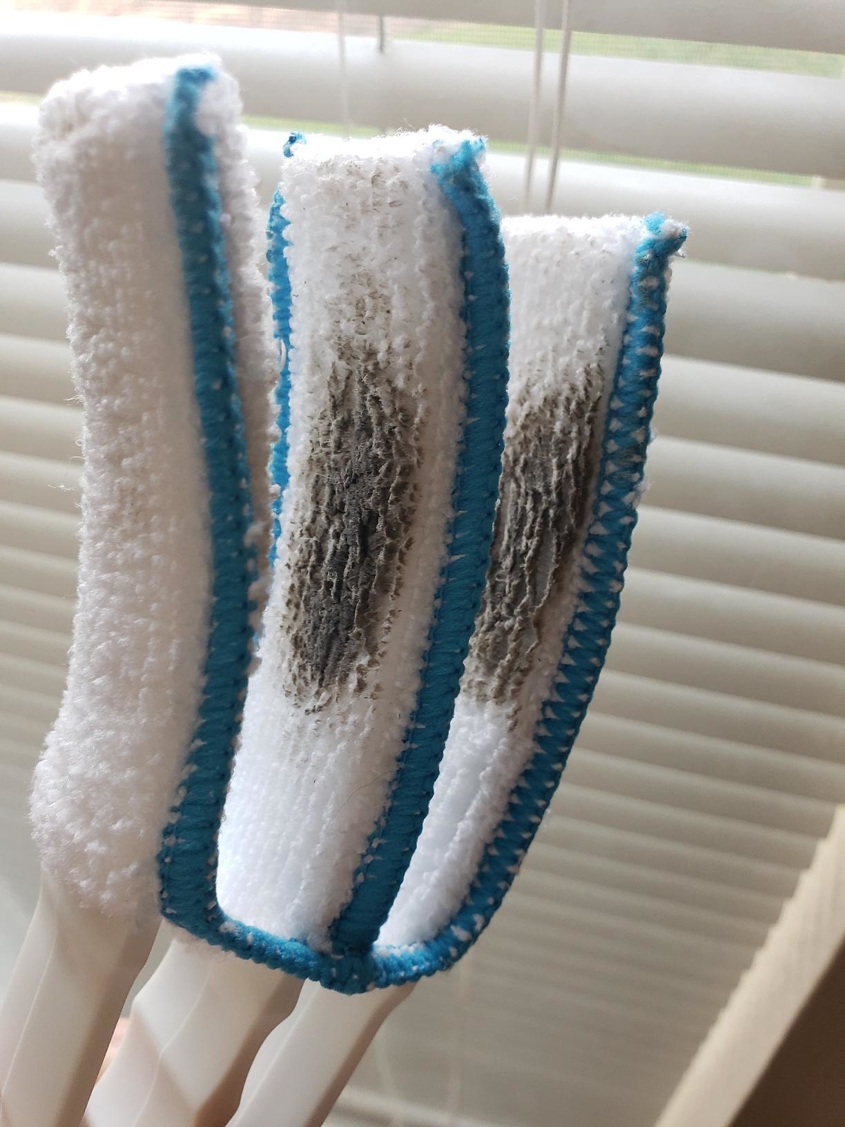 Reviewer&#x27;s photo of their blue and white duster after using it on their blinds