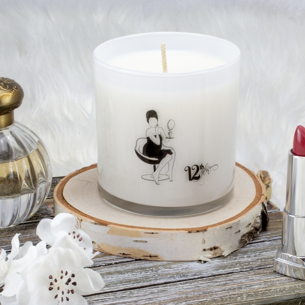 Clear candle with drawing of woman putting on makeup that says &quot;12th Glow&quot;