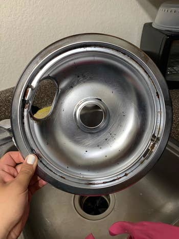 Reviewer's grease-covered electric burner before using the phosphate-free surface scrub