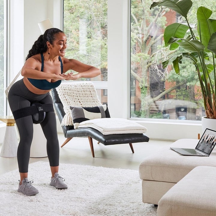 model using the equipment to workout in their living room