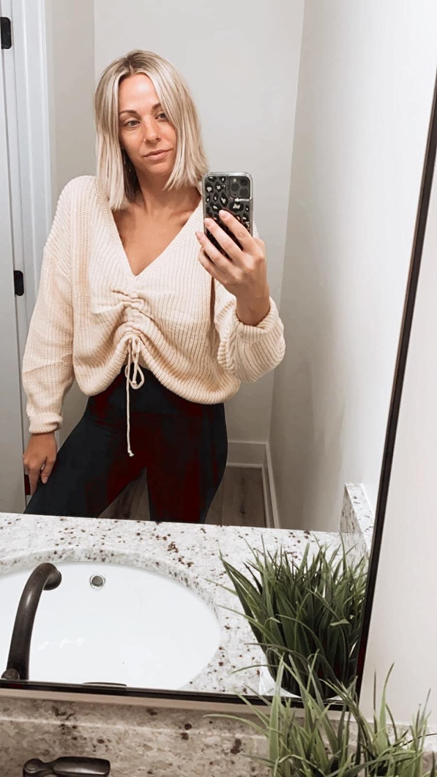 A reviewer in the cropped sweater in cream