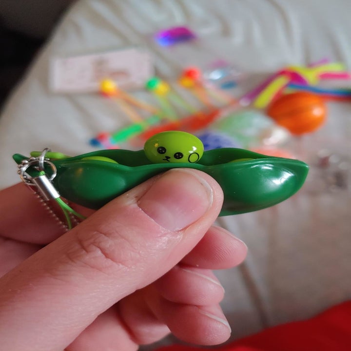 Reviewer holding pea stress toy
