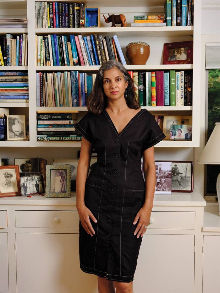 Radhika Jones stands in  front of a book shelf facing the camera