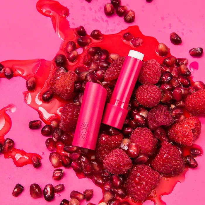 lip balm on a bed of strawberries and pomegranate seeds