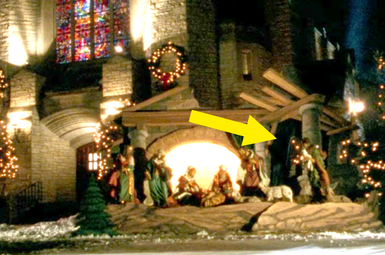 A nativity outside the church where the green curtain is hanging back up again