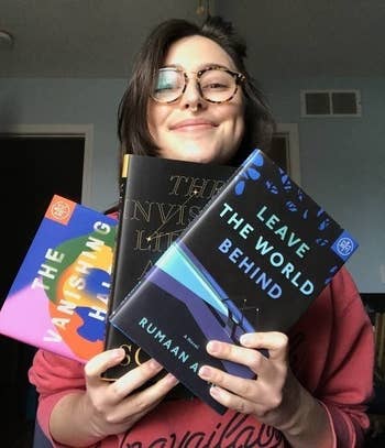 BuzzFeed Editor Rachel Dunkel holding three books: The Vanishing Half by Brit Bennett, The Invisible Life of Addie LaRue by V E Schwab, and Leave The World Behind by Rumaan Alam