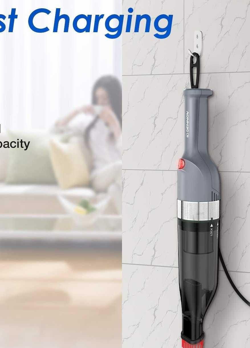 A handheld vacuum hanging on a wall in its charging unit