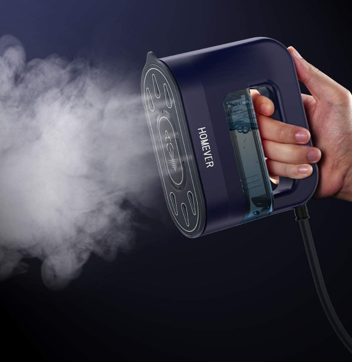 A person holding the handheld steamer while it blows out steam