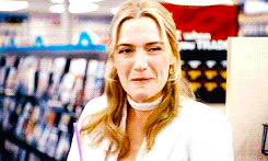 Kate Winslet/Iris giggles and shushes Jack Black/Miles as he sings in the Blockbuster