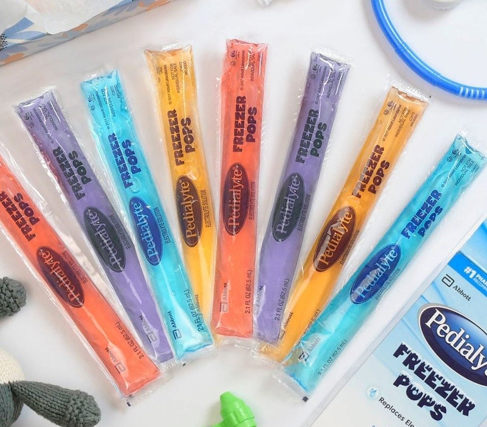 Eight freezies splayed out on a table next to its packaging 