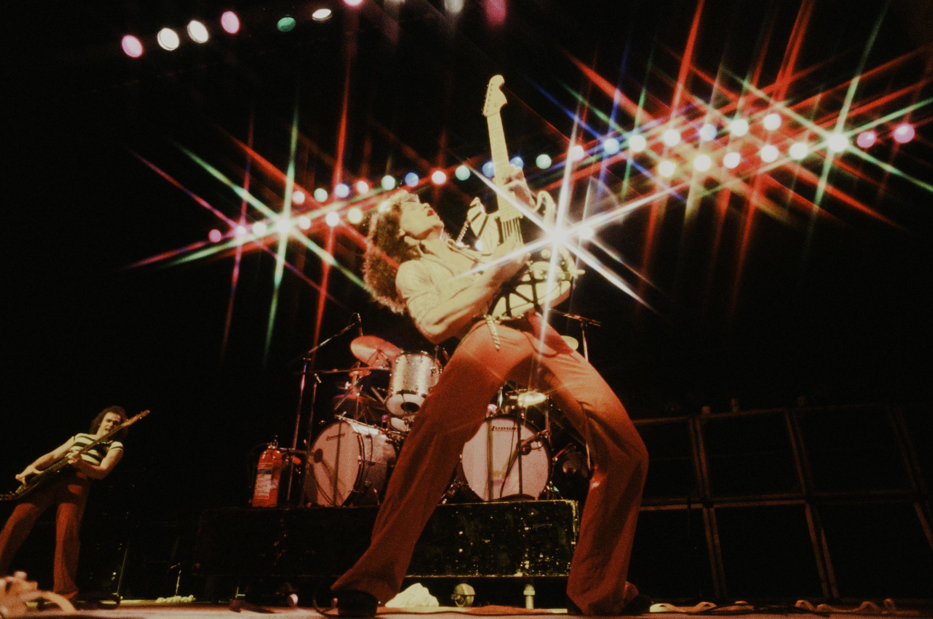 Man playing electric guitar on stage with bright lights