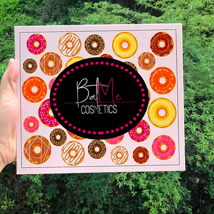 a hand holding the palette with doughnuts on the front