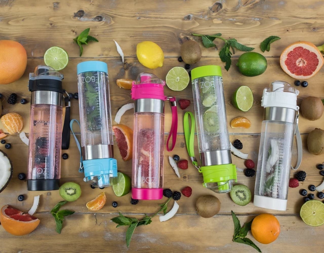 Several bottles together with fruit surrounding them