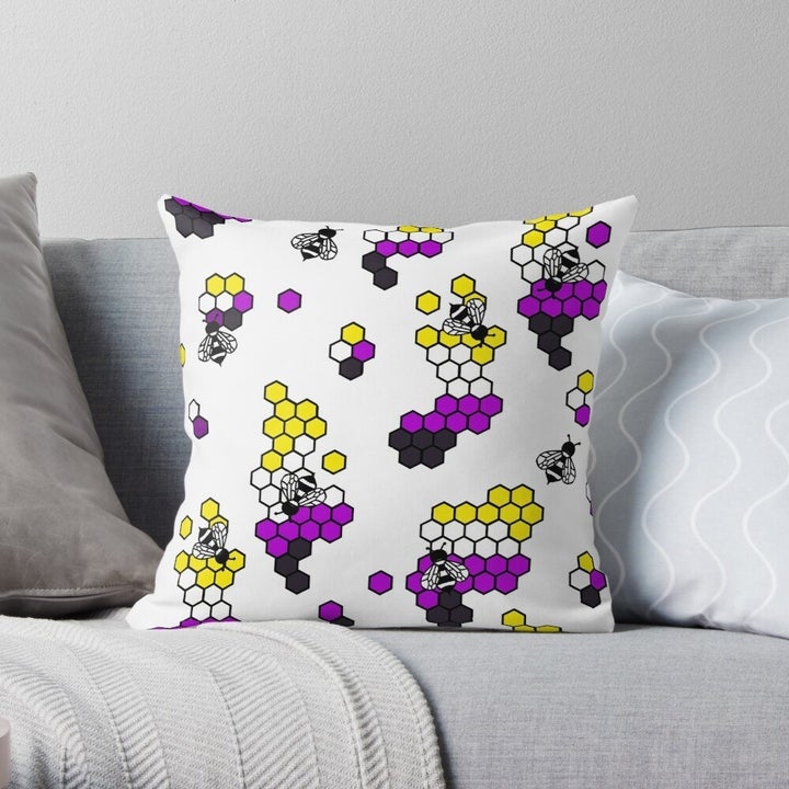 the square pillow with bees on nonbinary pride colored hives (black, purple, yellow, and white)