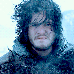Jon Snow grimacing in a snowstorm with his hair flying everywhere 