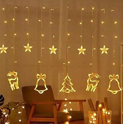 A curtain light with stars and reindeers, bells, and Christmas trees.