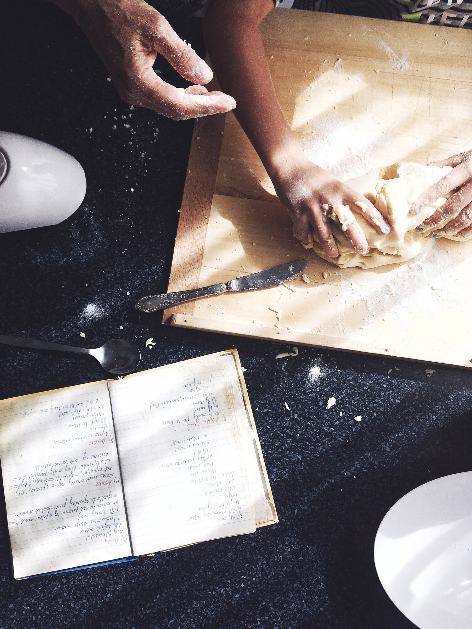 An older family member helping a child make a baking recipe