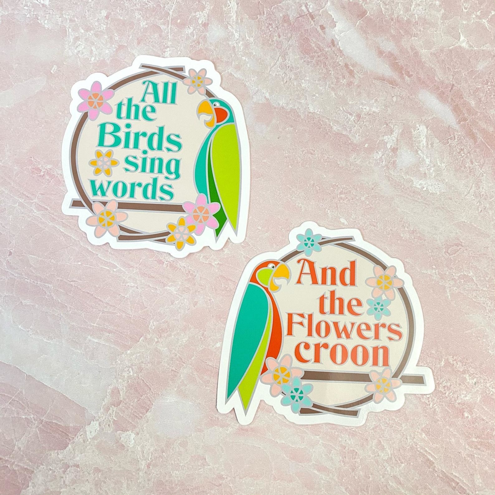 two stickers with parrots on each one, one says &quot;all the birds sing words&quot; and the other says &quot;and the flowers croon&quot;