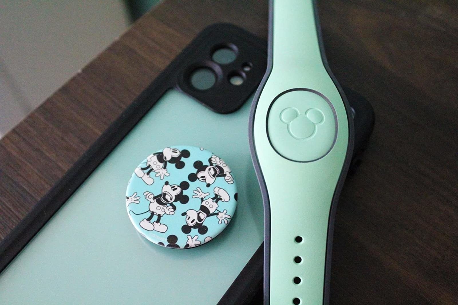 a reviewer&#x27;s phone with a light blue popsocket with an all-over print of mickey