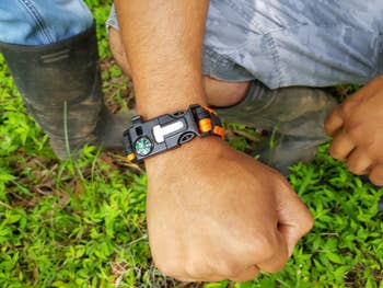 A reviewer showing the bracelet with the compass