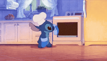 Stitch from Lilo and Stitch taking a cake out of the oven.