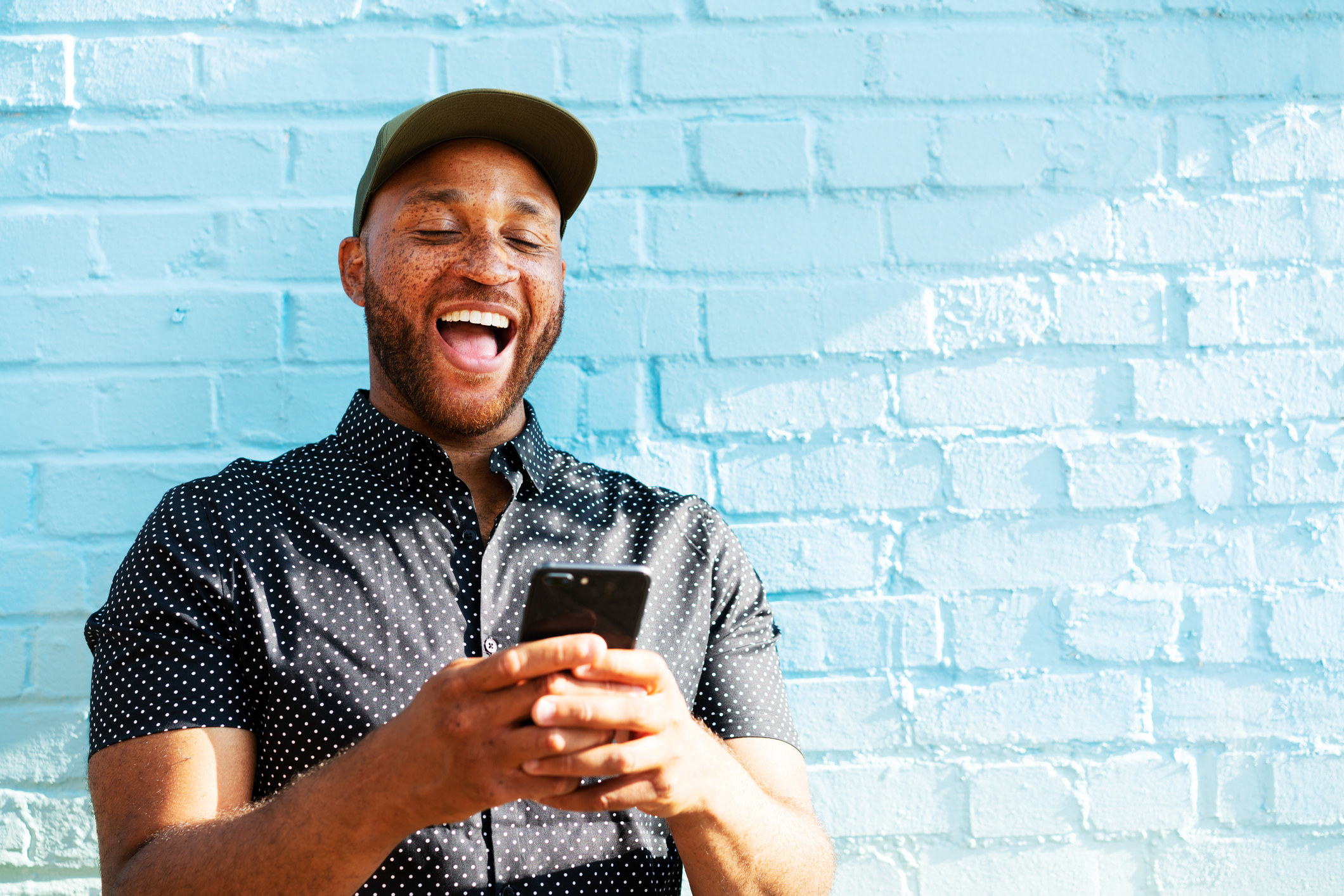 A person laughing at a video they are watching on their phone