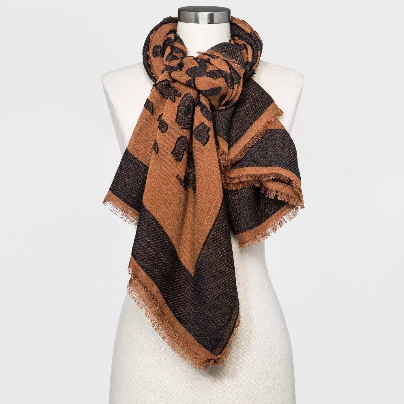 A black and brown scarf that is tied
