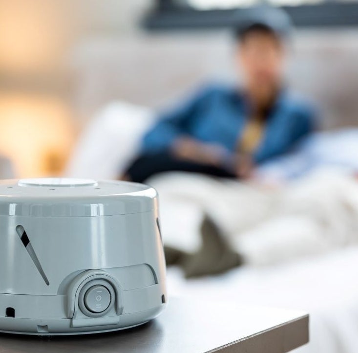 gray white noise machine sitting on top of a bedroom dresser