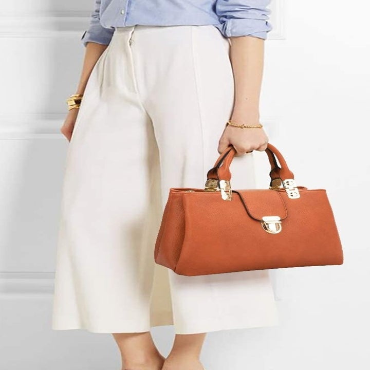 A model carrying the brown purse with gold hardware